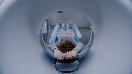 Foto de La mujer caucásica se somete a una resonancia magnética o una tomografía computarizada en el hospital, se revisa en la clínica con tecnologías médicas avanzadas. La paciente yace en el escáner esperando el diagnóstico. Prevención del cáncer. - Imagen libre de derechos