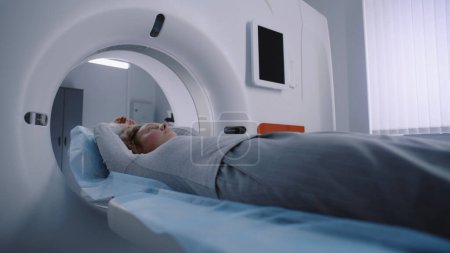 Photo for Process of emergency check up procedure with advanced medical technologies. Female patient lies at MRI or CT or PET scan machine. High-tech modern medical equipment. Healthcare Service. Close up shot. - Royalty Free Image