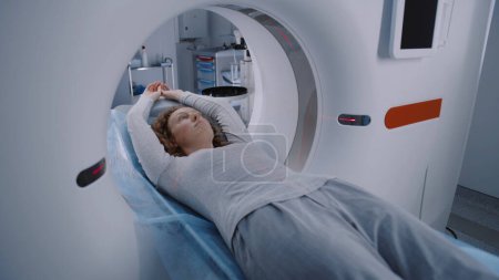Photo for Process of emergency check up procedure with advanced medical technologies. Female patient lies at MRI or CT or PET scan machine. High-tech modern medical equipment. Healthcare Service. Close up shot. - Royalty Free Image