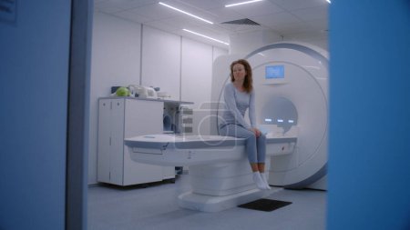 Photo for Female doctor, radiologist controls and turns on MRI or CT scan machine for female patient. Caucasian woman undergoing cancer prevention check up in modern clinic with advanced medical technologies. - Royalty Free Image