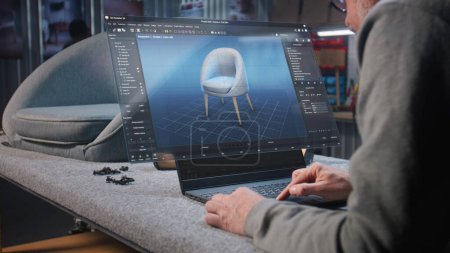 Téléchargez les photos : Le concepteur de meubles crée le modèle 3D numérique de chaise en bois élégante, prépare le projet de menuiserie sur ordinateur portable. Affichage virtuel olographe du logiciel professionnel ai pour la conception de meubles et la modélisation 3D. - en image libre de droit