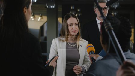 Une femme politique positive ou consul de l'Union européenne répond aux questions des journalistes et accorde une interview aux médias et à la télévision dans les bâtiments du gouvernement. Discours politique à la conférence de presse.