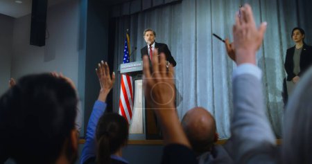 Photo for Presidential of USA candidate delivers campaign speech, answers questions, gives interview. American republican politician performs at meeting with press. Election day. Backdrop with American flags. - Royalty Free Image