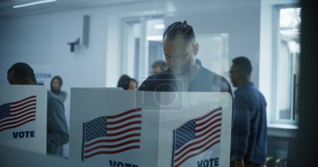 Male Caucasian citizen comes to vote in booth in polling station office. National Election Day in the United States. Political races of US presidential candidates. Civic duty and patriotism concept.