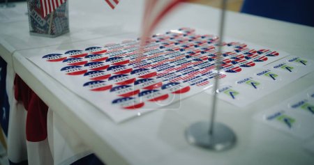 Wahlen in den Vereinigten Staaten von Amerika. Großaufnahme von patriotischen Aufklebern mit dem Logo der amerikanischen Flagge und Inschriften, die auf dem Tisch liegen. Präsidentschaftswahlkampf und Wahlberichterstattung. Bürgerpflicht und Patriotismus.