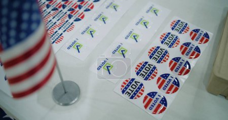 Großaufnahme von patriotischen Aufklebern mit dem Logo der amerikanischen Flagge und Inschriften, die auf dem Tisch liegen. Wahlen in den Vereinigten Staaten von Amerika. Präsidentschaftswahlkampf und Wahlberichterstattung. Demokratie und Patriotismus.