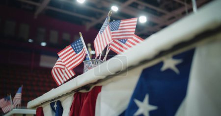 Wahlen in den Vereinigten Staaten von Amerika. Großaufnahme des Tisches für die Wählerregistrierung mit amerikanischen Flaggen, die im Wahllokal stehen. Präsidentschaftswahlkampf und Wahlberichterstattung. Bürgerpflicht und Patriotismus.