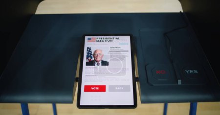 Wahlkabine am Wahllokal mit Tablet-Computer. Informationen über den US-Präsidentschaftskandidaten und Wahlbuttons auf dem Bildschirm. Moderne digitale Wahltechnologie. Wahlen in den Vereinigten Staaten.
