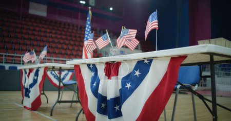 Tisch für Wählerregistrierung mit amerikanischen Flaggen steht im Wahllokal. Wahlen in den Vereinigten Staaten von Amerika. Präsidentschaftswahlkampf und Wahlberichterstattung. Bürgerpflicht, Patriotismus und Demokratie.