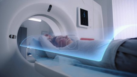 Frau wird im MRT oder CT diagnostiziert, liegt auf dem Bett und bewegt sich im Inneren der Maschine. VFX-Animation des Gehirns und des Körpers einer Patientin. Sci-Fi-Augmented-Reality-Geräte im modernen medizinischen Labor.