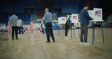 Photo for Vote here sign on the floor. Queue of multi ethnic American citizens come to vote in polling station. National Election Day in United States. Political races of US presidential candidates. Civic duty. - Royalty Free Image