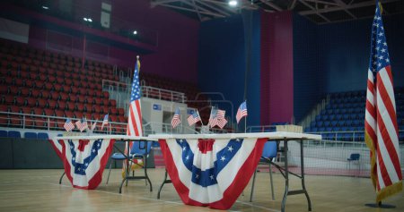 Wahlen in den Vereinigten Staaten von Amerika. Tisch für Wählerregistrierung mit amerikanischen Flaggen steht im Wahllokal. Präsidentschaftswahlkampf und Wahlberichterstattung. Bürgerpflicht, Patriotismus und Demokratie.