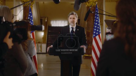 Der selbstbewusste Präsident der Vereinigten Staaten spricht auf einer Pressekonferenz im Weißen Haus, gibt Interviews für Medien und Fernsehnachrichten. Minister spricht politische Rede. Amerikanische Flaggen im Hintergrund.
