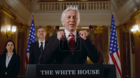 Photo for US presidential candidate says inspirational campaign speech in the White House, journalists applaud. Minister or congressman speaks at press conference for media and television. Election coverage. - Royalty Free Image