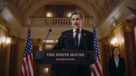 Photo for US President pronounces inspirational political speech in the White House. Mature American minister or USA government representative speaks for media and television at press conference in Congress. - Royalty Free Image