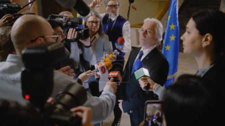 Photo for EU representative answers press questions and gives interview for TV breaking news. Senior consul surrounded by crowd of journalists. Political speech during press conference. State of the nation. - Royalty Free Image