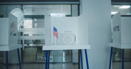 Dolly Shot von Wahlkabinen mit dem Logo der amerikanischen Flagge in einem hellen Wahllokal Büro. Nationaler Wahltag in den Vereinigten Staaten von Amerika. Politische Rennen der US-Präsidentschaftskandidaten. Demokratie.