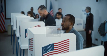 Téléchargez les photos : Un citoyen afro-américain vient voter dans un bureau de vote. Journée nationale des élections aux États-Unis. Courses politiques des candidats à la présidence américaine. Devoir civique et concept de patriotisme. - en image libre de droit
