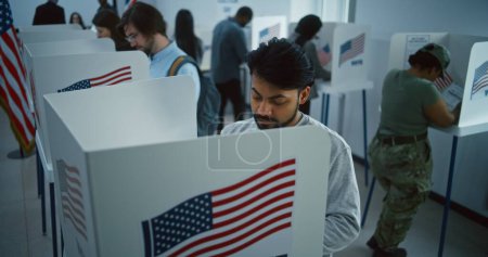Téléchargez les photos : Un Indien, un citoyen américain vote dans un bureau de vote. Journée nationale des élections aux États-Unis. Courses politiques des candidats à la présidence américaine. Devoir civique et patriotisme. Dolly shot. - en image libre de droit