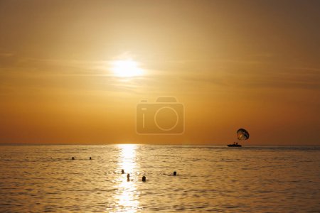 Photo for People swim in the sea at sunset in Turkey. - Royalty Free Image
