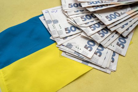 Téléchargez les photos : Monnaie ukrainienne sur drapeau national bleu jaune, finances conccept. Uah hrn gryvnia - en image libre de droit