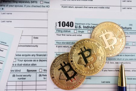 Photo for Form 1040 with pen bitcoin coins calculator financial document. Paperwork. tax forms submission of citizens' taxes - Royalty Free Image