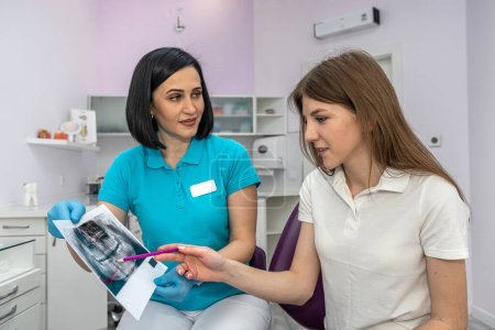 Photo for A young beautiful girl patient came for a consultation with a female dentist in a private clinic. Concept of female dentist. patient consultation. healthy teeth - Royalty Free Image