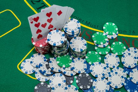 Téléchargez les photos : Jetons de poker avec des cartes à jouer sur la table de casino verte. Le jeu. jeu de table. jeu de société - en image libre de droit