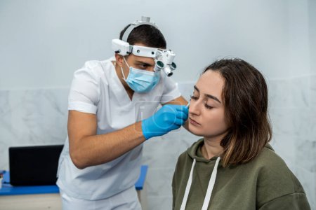 Foto de Médico examina los oídos de un paciente durante un examen médico. medicina. paciente con dolor de oídos - Imagen libre de derechos