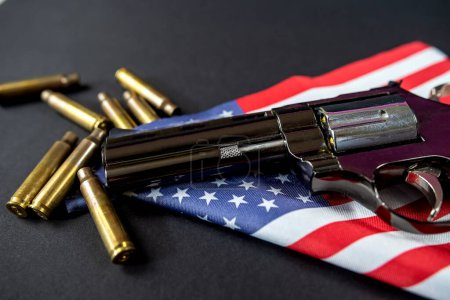 Téléchargez les photos : Revolver noir et munitions sur le drapeau plié des États-Unis est contre la constitution des États-Unis. La violence. interdire la vente d'armes illégales. - en image libre de droit