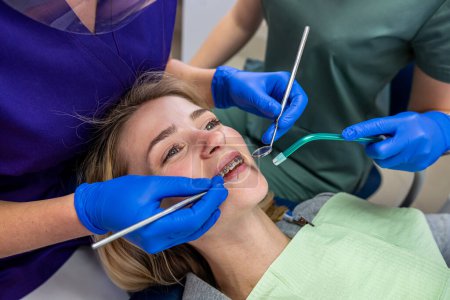 Foto de En una clínica dental especializada, una dentista recibe clientes con problemas dentales. Concepto de tratamiento dental - Imagen libre de derechos