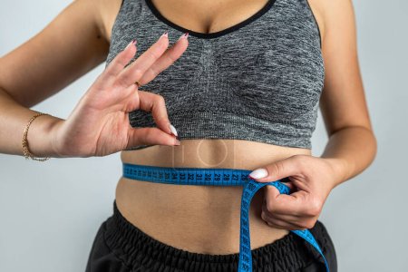Photo for Portrait of a circumcised female figure who is sad about measuring her body size with a tape measure. Healthy Lifestyle. diets - Royalty Free Image
