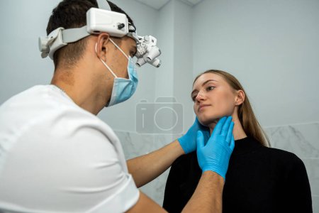 Photo for Young female patient came to see a ENT doctor with throat problems. the doctor makes an examination. - Royalty Free Image