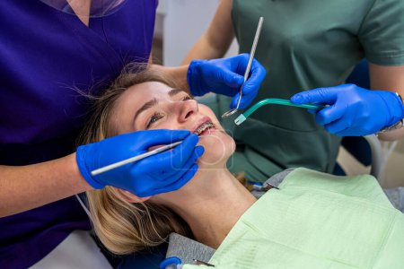 Foto de Dentista joven mujer diagnostica y trata los dientes en una nueva paciente. El concepto de tratamiento dental en el dentista. - Imagen libre de derechos