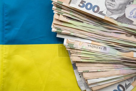 Téléchargez les photos : Ukrainian hryvnia lying on national blue yellow flag of Ukraine. Uah - en image libre de droit