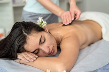 Téléchargez les photos : Doctor doing medical procedure with special gua sha scrapers for relax massage. Beauty and rejuvenation skin concept - en image libre de droit
