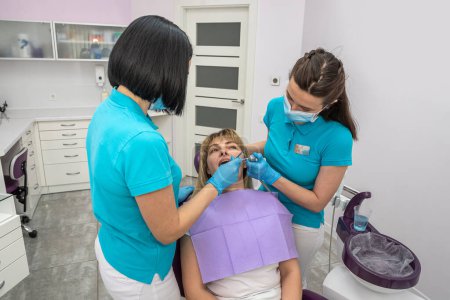 Photo for Beautiful young female patient came for a routine examination in modern dentistry. The concept of routine dental examination - Royalty Free Image