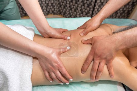 Photo for Massage in four hands over the patient's back is performed by two massage therapists, a woman and a man, at the same time. effective therapeutic massage. spa salon healthy body - Royalty Free Image