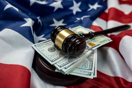 Photo for Hundred dollar bills and a judge's gavel placed on an American flag. isolated Justice in the country. Bribery and bribery of the authorities - Royalty Free Image