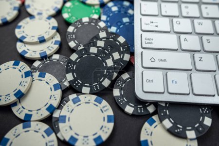 computer keyboard or laptop with poker chips placed on a plain background. isolated Gambling online casino internet betting concept. Jackpot. chips casino.