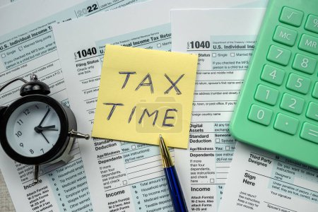 yellow sticker with world Tax Time on 1040 tax form, Tax concept deadline