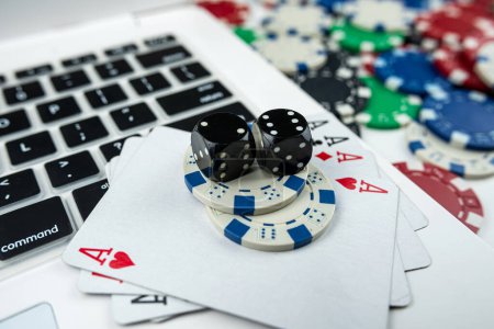 Téléchargez les photos : Poker en ligne avec des jetons de cartes à jouer pour ordinateur portable et des dés. Jeu en ligne casino concept - en image libre de droit