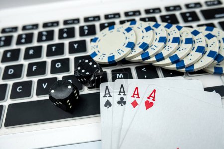 Online-Poker mit Laptop-Spielkartenchips und Würfeln. Online Glücksspiel Casino Konzept
