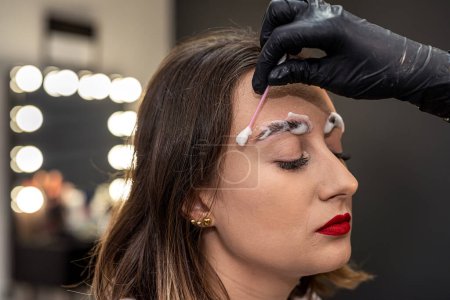 Photo for An eyebrow artist is laminating the eyebrows of a beautiful client. eyebrows eyebrow painting lamination - Royalty Free Image