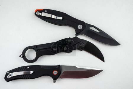 Foto de Tres cuchillos de combate tácticos negros aislados en blanco. arma - Imagen libre de derechos