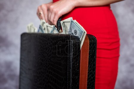 Foto de Closeup of female holding briefcase with money as bribery. Corruption illegal concept - Imagen libre de derechos