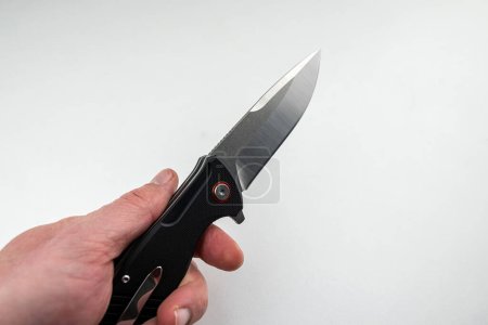 Photo for Closeup hand holding a tanto combat knife isolated on white. weapons - Royalty Free Image