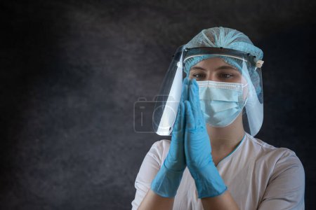 Photo for Portrait woman doctor in uniform closed her eyes, clasped her hands and praying to God. Concept of  faith and hope - Royalty Free Image