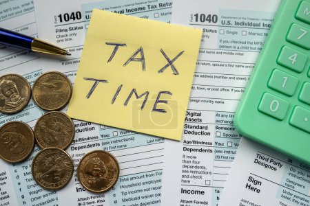 Foto de US individual income 1040 tax form with US coin and calculator, finance taxation concept - Imagen libre de derechos