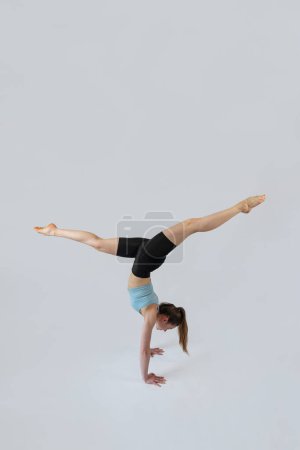 Foto de Mujer caucásica delgada usar ropa deportiva haciendo relajación yoga ejercicio práctica equilibrio asanas aisladas en blanco. concepto de estilo de vida saludable - Imagen libre de derechos